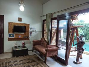 a living room with a chair and a television at Calmness Villa Syariah in Sekupang