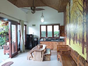 a kitchen with a wooden table and benches in a room at Calmness Villa Syariah in Sekupang