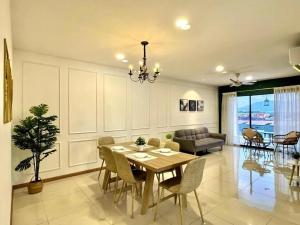 a dining room and living room with a table and chairs at Manhattan Premier Suites IPOH Waterpark by uBook in Ipoh