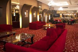 a lobby with red chairs and a table at Grand Serpong Hotel in Panunggangah
