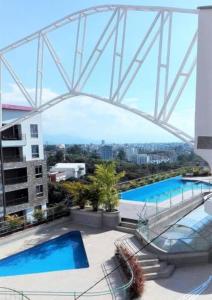 un ponte sopra due piscine in cima a un edificio di APARTAMENTO EN ATLANTIS VISTA UNICA PISCINA JACUZZIi ad Armenia