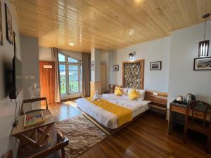 a bedroom with a large bed and a wooden ceiling at Bahar Retreat And Spa , Gangtok in Gangtok