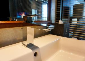 a bathroom sink with a faucet on top of it at Boton Blue Hotel & Spa in Nha Trang