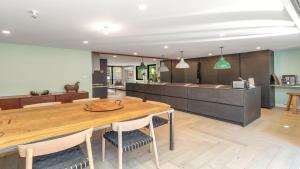 a kitchen and dining room with a wooden table and chairs at Aunty Olive's - Pearl Beach in Pearl Beach