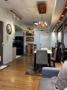 a living room with a dining table and a kitchen at Velasco Place in Manila