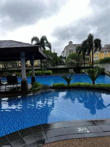 a large blue swimming pool with a gazebo at Velasco Place in Manila