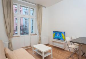 a living room with a tv and a table at Hugo Apartment Prague in Prague