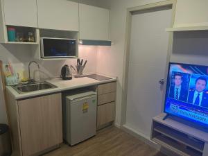 a kitchen with a sink and a tv in a room at Great Value Apartment in Bang Khen