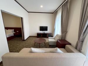 a living room with a couch and a tv and a bedroom at JOM at deRiviera Self check-in in Melaka
