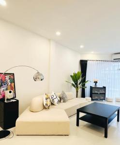 a living room with a couch and a coffee table at Fivehouse Silom2 soi11 City heart Silom BTS 7min in Bang Rak