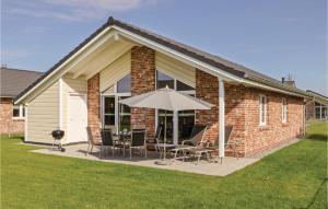 a patio with a table and an umbrella at Nice Home In Dagebüll With Sauna in Dagebüll +22 photos