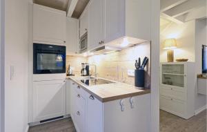 eine weiße Küche mit weißen Schränken und einer Spüle in der Unterkunft Seehund in Süssau