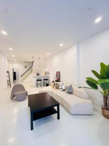 a white living room with a couch and a table at Fivehouse Silom2 soi11 City heart Silom BTS 7min in Bang Rak