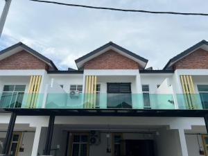 a house with glass balconies in front of it at Meera Homestay in Malacca