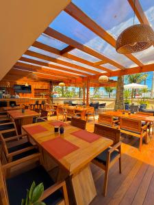 a restaurant with wooden tables and wooden chairs at Luna Hotel Boutique - Frente à Praia in Guarujá