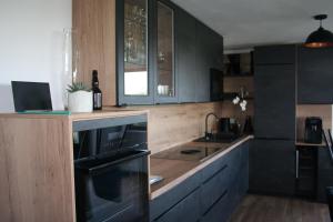 a kitchen with black cabinets and a counter with a sink at Rebenchalet in Sankt Anna am Aigen