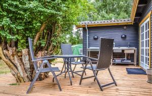 a patio with three chairs and a table and a grill at Holiday Home Køgehusvej in Frederiksværk