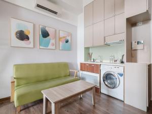 a living room with a green couch and a washing machine at CJ Hotel in Taipei