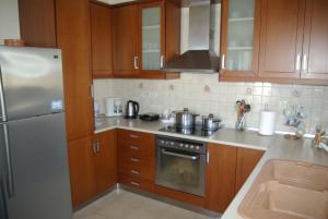 a kitchen with wooden cabinets and a stainless steel refrigerator at Manos House in Monólithos