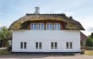 a thatched roof house with a window at Two-Bedroom Holiday Home In Grasten in Gråsten