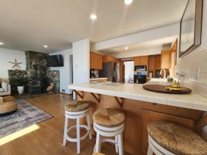 a kitchen with a large island with bar stools at Warm Beach House Stanwood in Stanwood