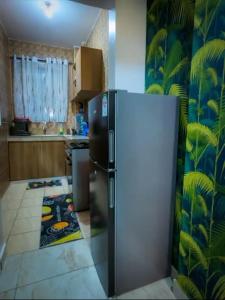 a kitchen with a refrigerator in a room at Soft Greys Homes in Mombasa