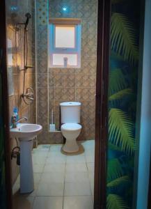 a bathroom with a toilet and a sink at Soft Greys Homes in Mombasa