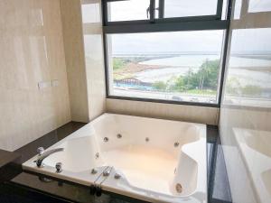 Fair Tale Motel - Sea في مدينة هوالين: حوض استحمام في حمام به نافذة كبيرة +41 صورة