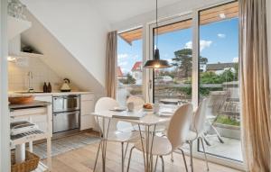 a kitchen with a white table and chairs and a large window at Awesome Apartment In Allinge in Allinge