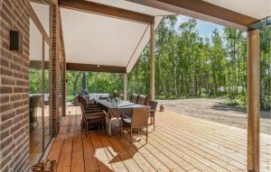 a wooden deck with a table and chairs on it at 4 Bedroom Stunning Home In Nexø in Neksø