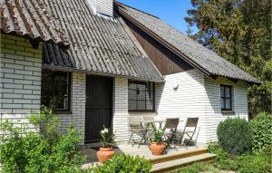 a white house with chairs on a porch at Amazing Home In Nexø With Kitchen in Neksø