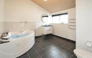 a white bathroom with a tub and a toilet at Holiday Home Gunhildsvej Vestervig Xi in Vestervig