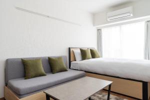 a living room with a bed and a couch at GRAN PASEO koenjiminami in Tokyo +21 photos