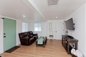 a living room with a leather couch and a table at River City Hideaway cottage in Grand Junction