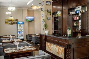 a bar in a restaurant with couches and tables at Park Hotel al Bustan in Shymkent