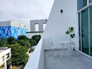 a balcony with a table and chairs on a building at Midtown Duplex Ratchayothin in Bangkok