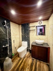 a bathroom with a toilet and a sink and a mirror at K K Gardens in Palakkad