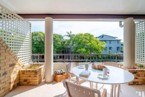 バイロンベイにあるByron Bayside Central Studio Apartmentsのパティオ(テーブル、椅子付)