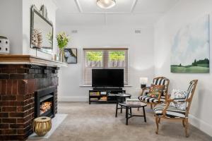 a living room with a fireplace and a tv at Two Terrific Albert Park Apartments in Albert Park