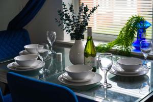 LoughtonにあるLuxury Home Away from Homeのガラステーブル(ワイン1本、グラス付)