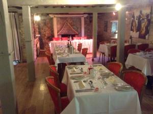 a dining room with white tables and red chairs at Swan Hotel in Wotton-under-Edge