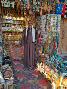 a man standing in front of a shop in a market at Osiris Guest House in Abu Simbel