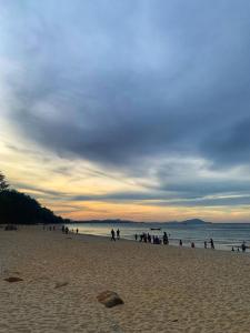 a group of people standing on a beach at D'Ebai Roomstay Kijal in Cukai