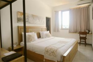 ウブドにあるME Rooms Ubud by ME Villasのベッドと机と窓のある寝室 +5枚の写真