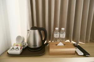 ウブドにあるME Rooms Ubud by ME Villasのコーヒーメーカー、ボトル入り飲料水(テーブル上)