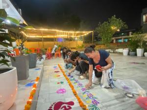 a group of people playing with rangoli on the floor at Holy Cow in Rishīkesh