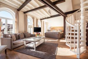 a living room with a couch and a table at TOP CityLine Klassik Altstadt Hotel Lübeck in Lübeck