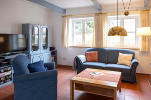 a living room with two chairs and a tv at Kaapdüne in Spiekeroog