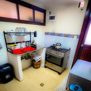 a small kitchen with a stove and a sink at Comodo amplio con lindas vistas sector embajadas piso alto in La Paz