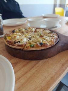 MiānīTSR Inn By Xplore Mantra Hotel and Cafe, Nagtibba的木桌上摆着的比萨饼